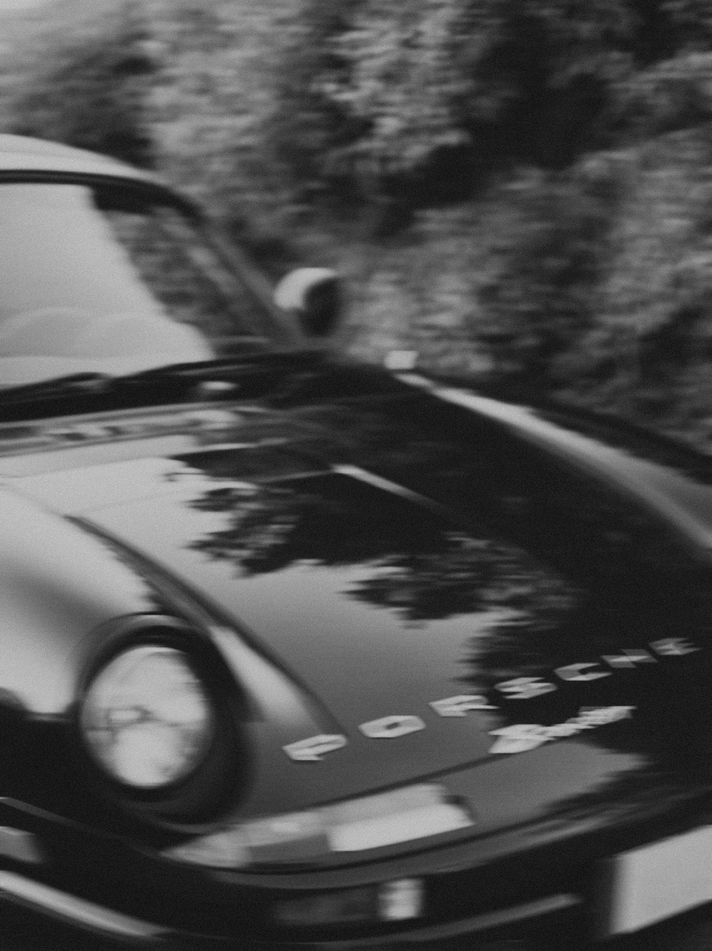 Black and white close-up of luxury car hood with motion blur effect